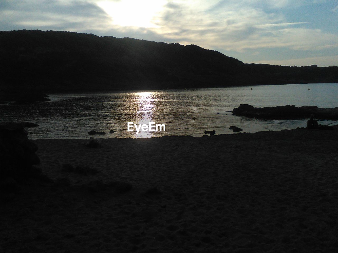 SCENIC VIEW OF SEA AND SILHOUETTE MOUNTAINS AGAINST SKY