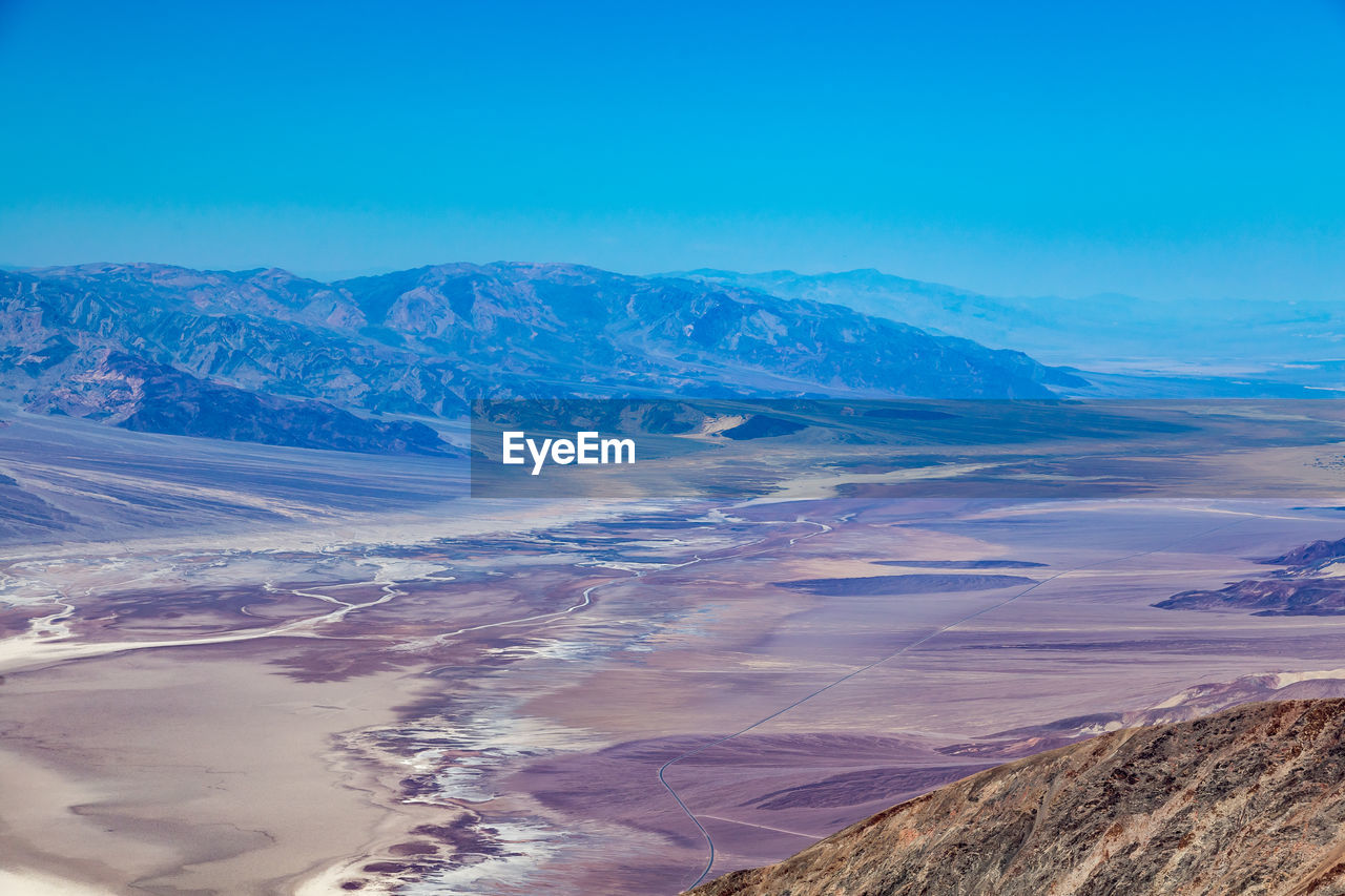 Scenic view of mountains against blue sky