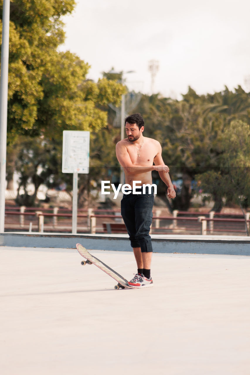 Man riding skateboard in urban street skatepark. casual guy wearing shorts and t-shirt.