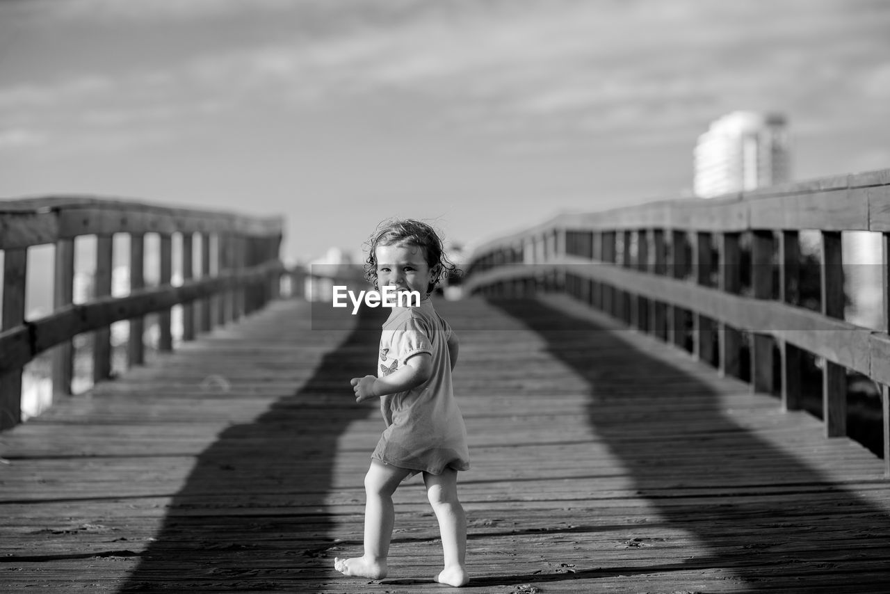 Portrait of cute child walking on footbridge