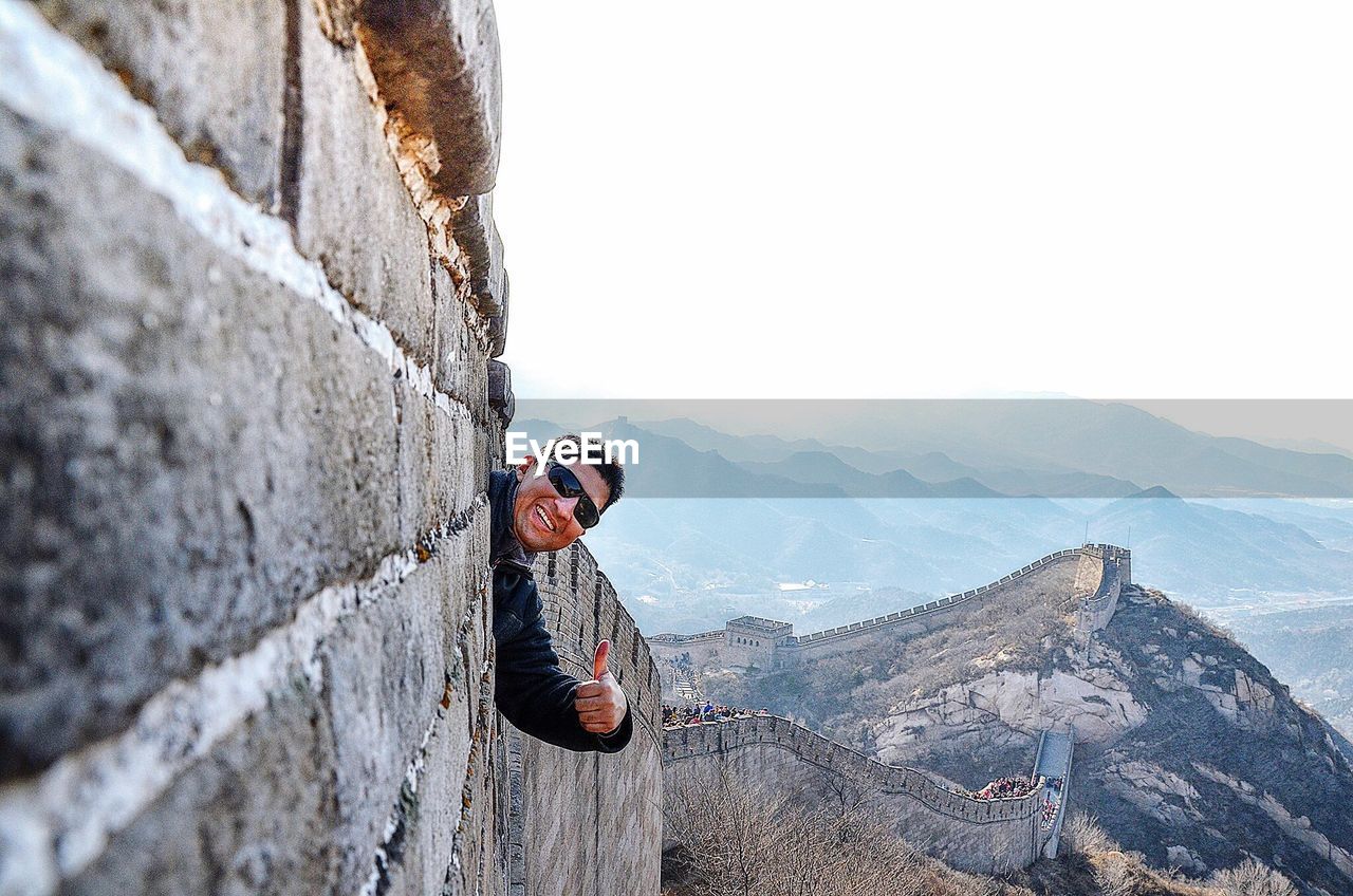 Man showing thumbs up at great wall of china