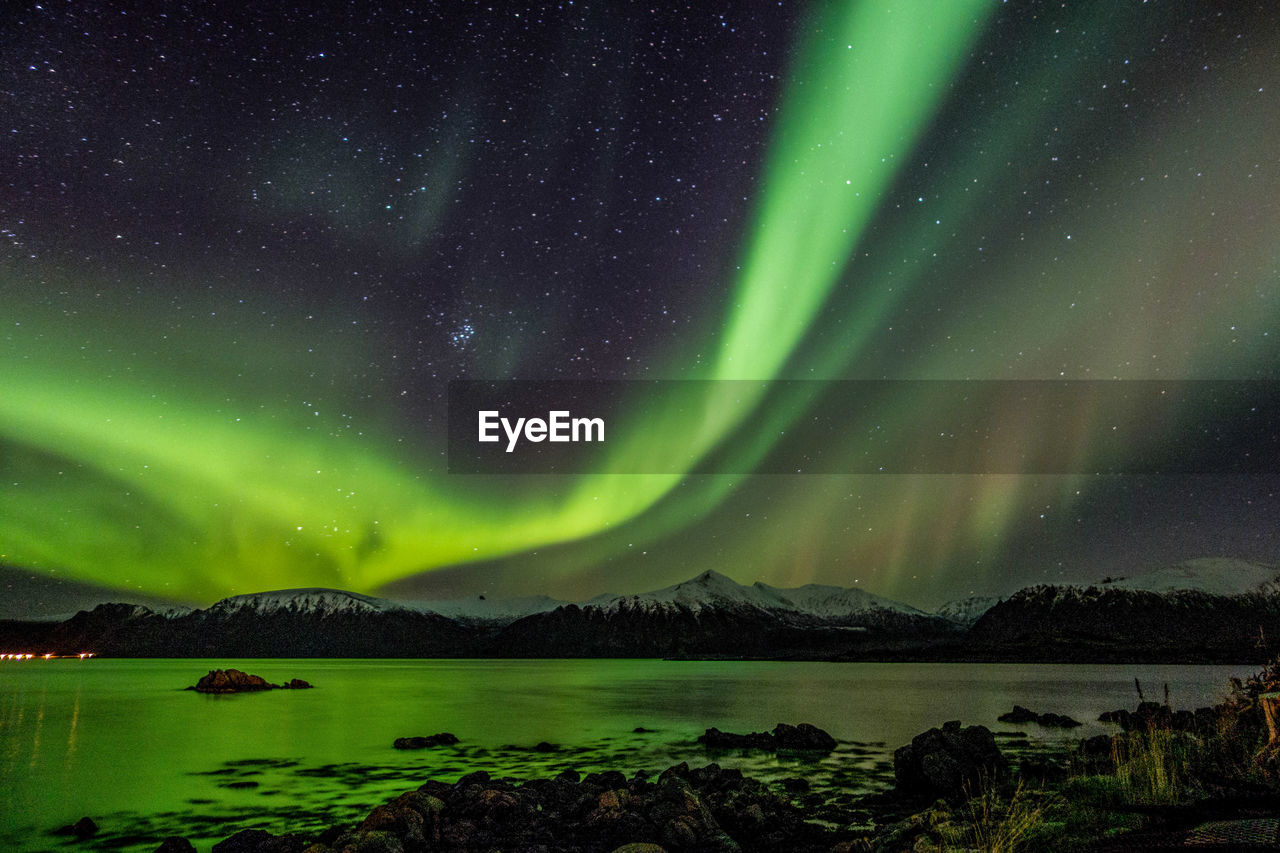 Scenic view of lake against mountains at night