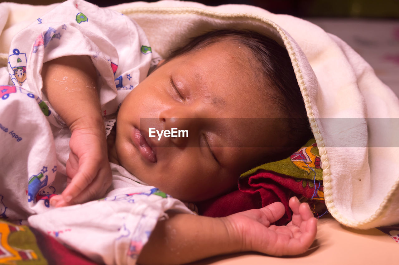 Close-up of cute baby sleeping at home