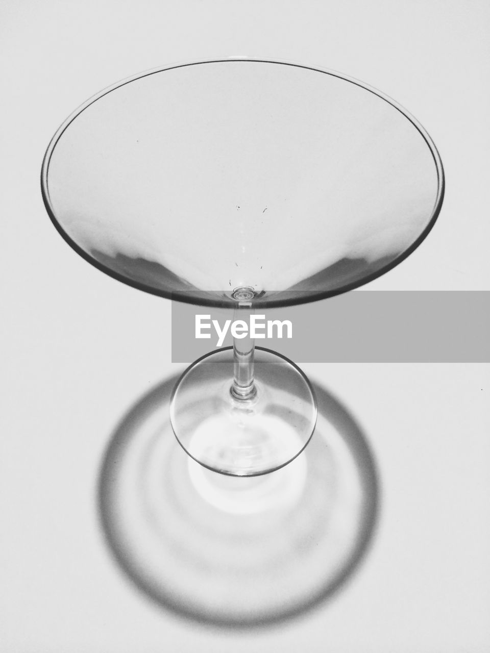 High angle view of empty martini glass over gray background