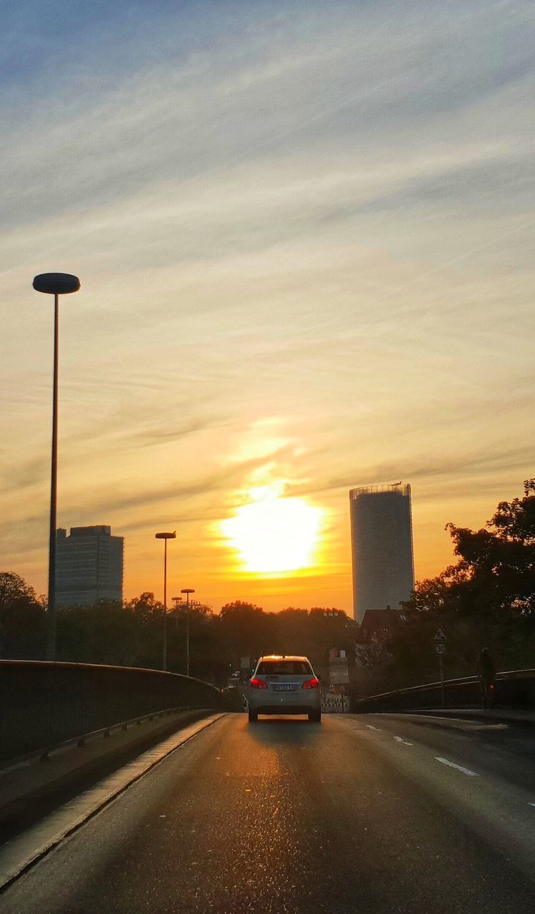 CARS ON STREET AGAINST SKY DURING SUNSET