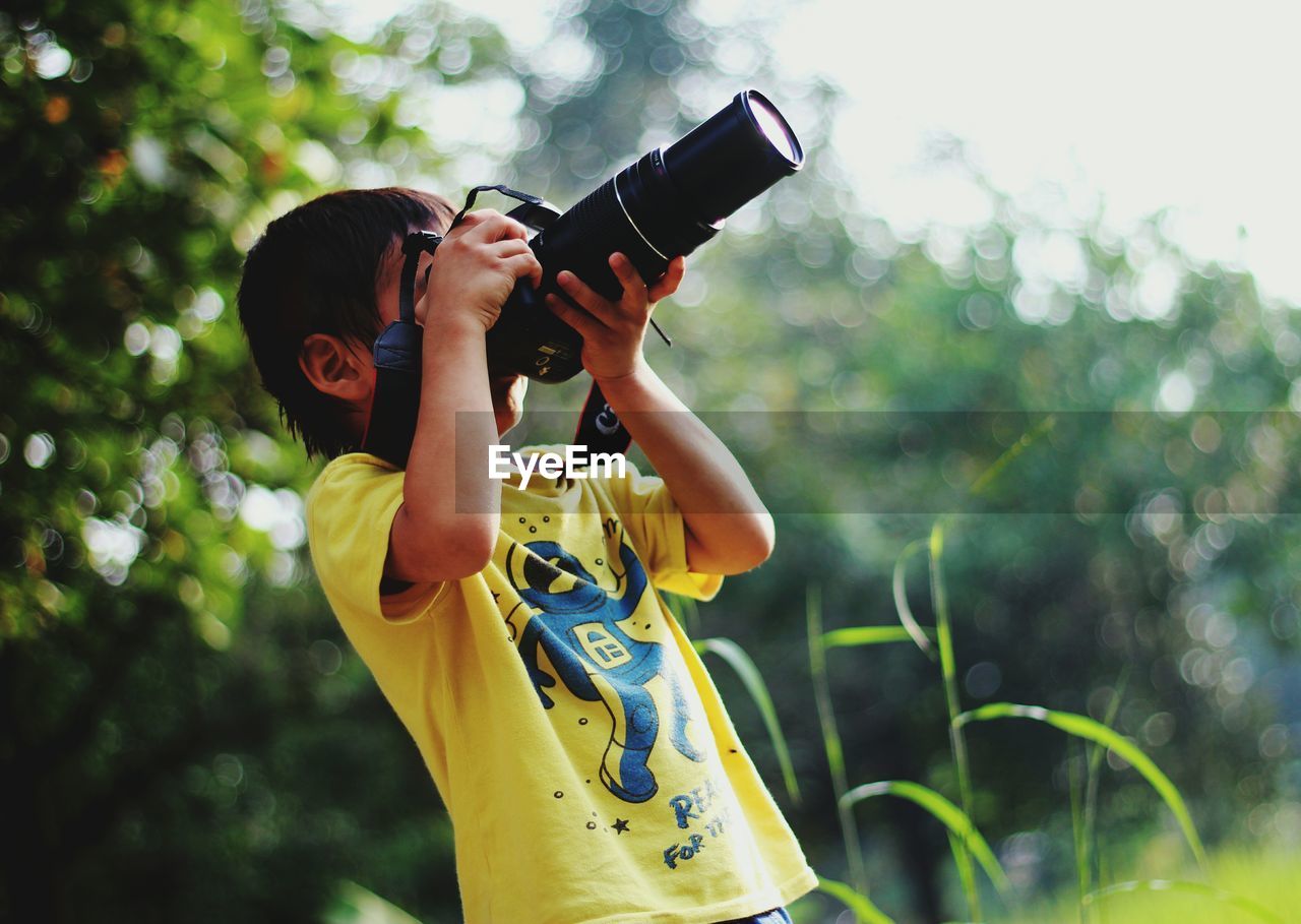 Boy photographing with digital camera