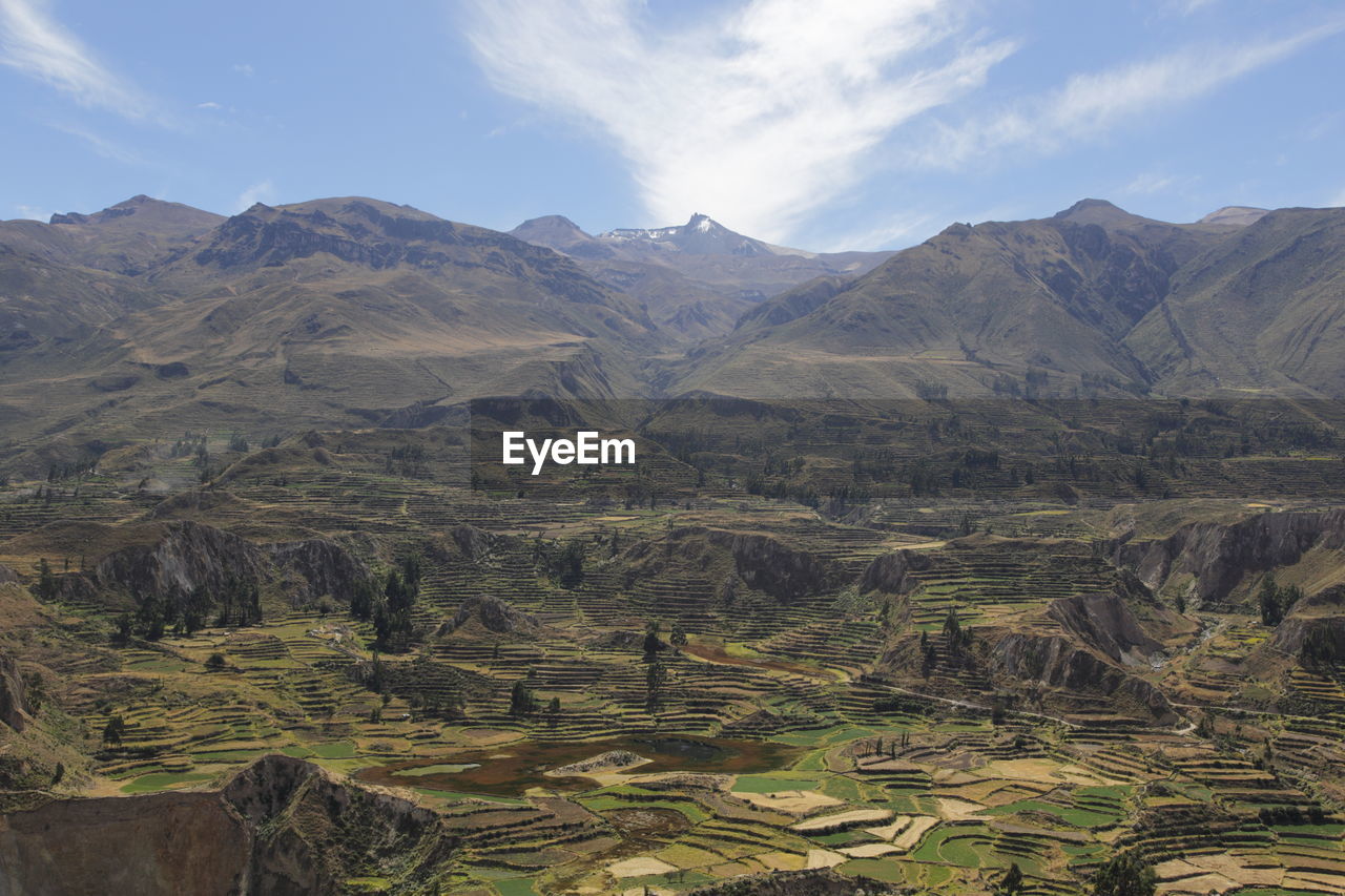 High angle view of field and mountains against sky