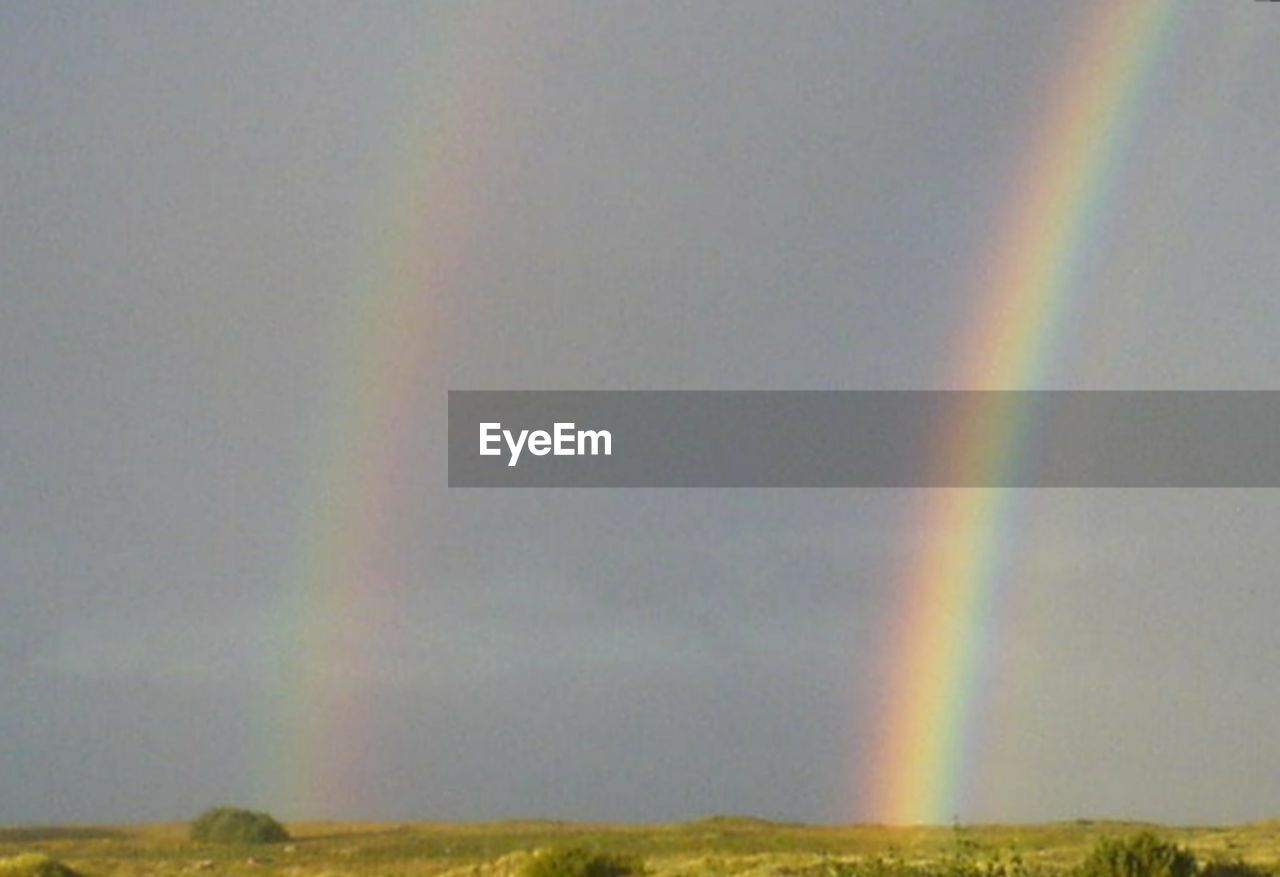 RAINBOW OVER LANDSCAPE AGAINST SKY