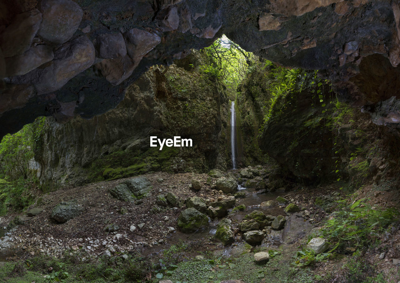 Scenic view of waterfall seen through cave