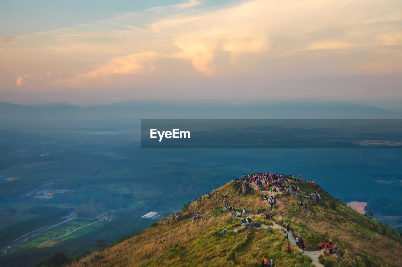 Aerial view of people on mountain peak against sky