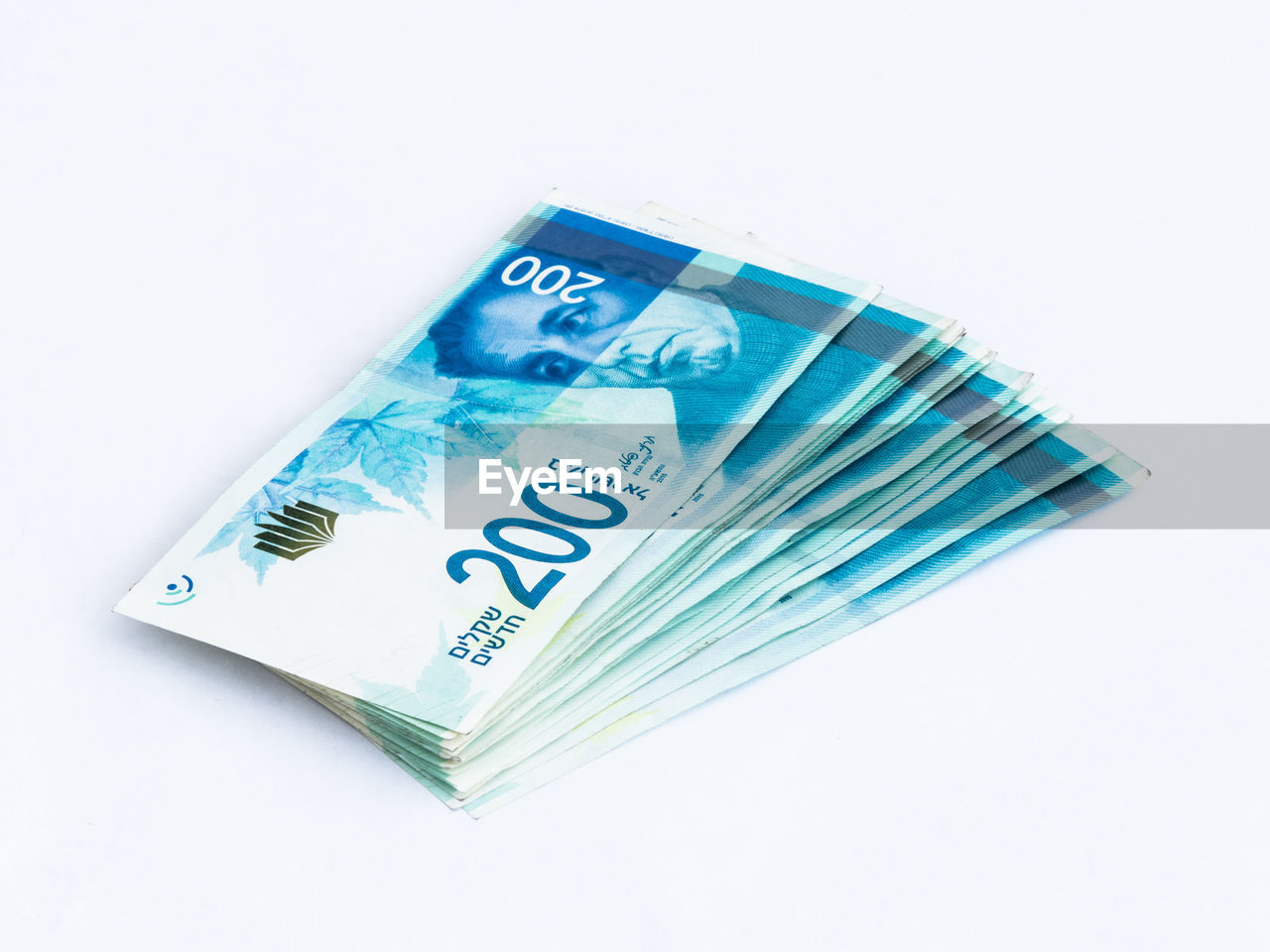 Close-up of 200 israeli shekel notes on white background