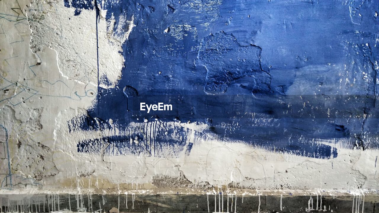 Full frame shot of weathered blue and white painted wall