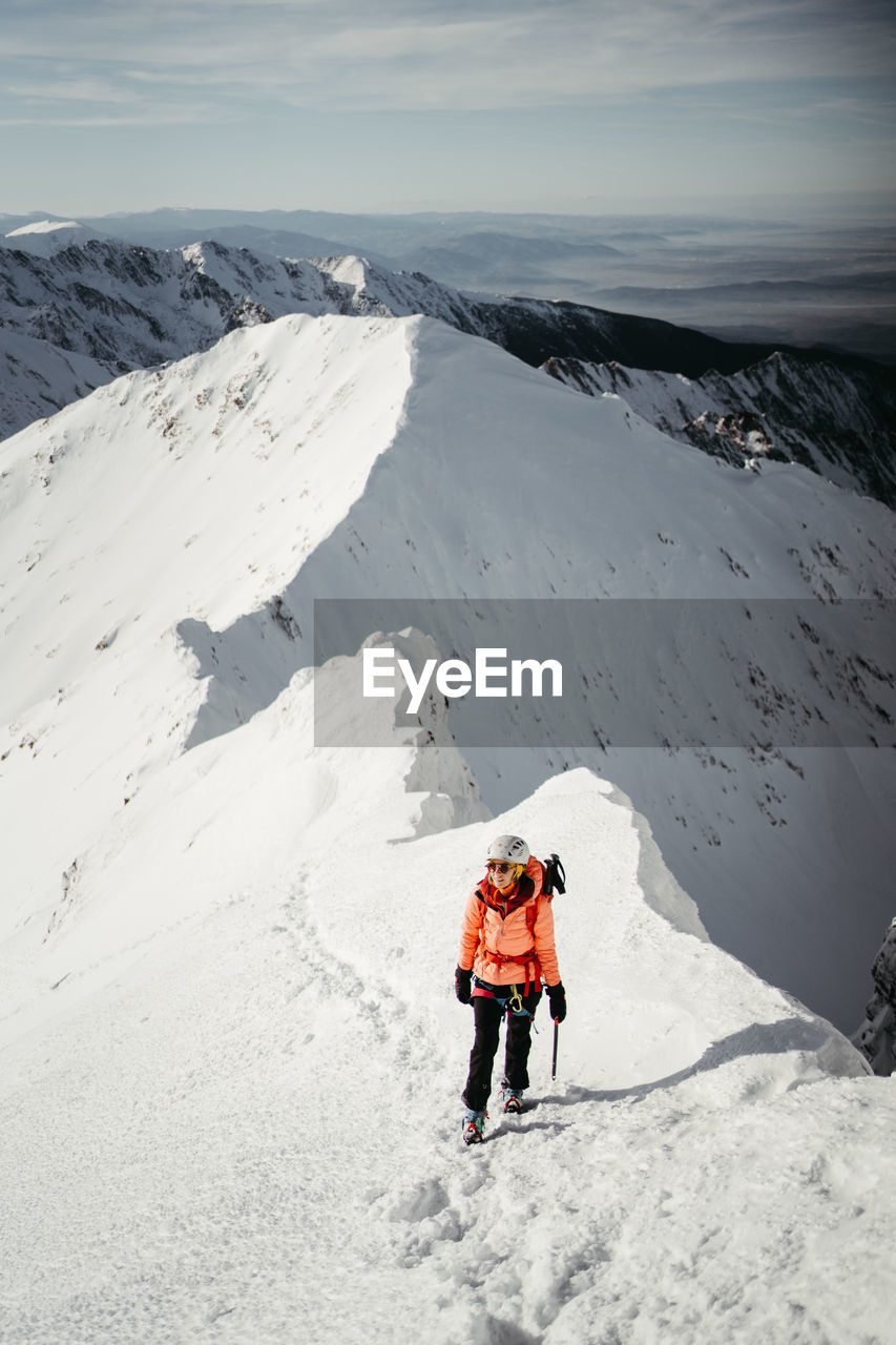 rear view of man walking on snow covered mountain