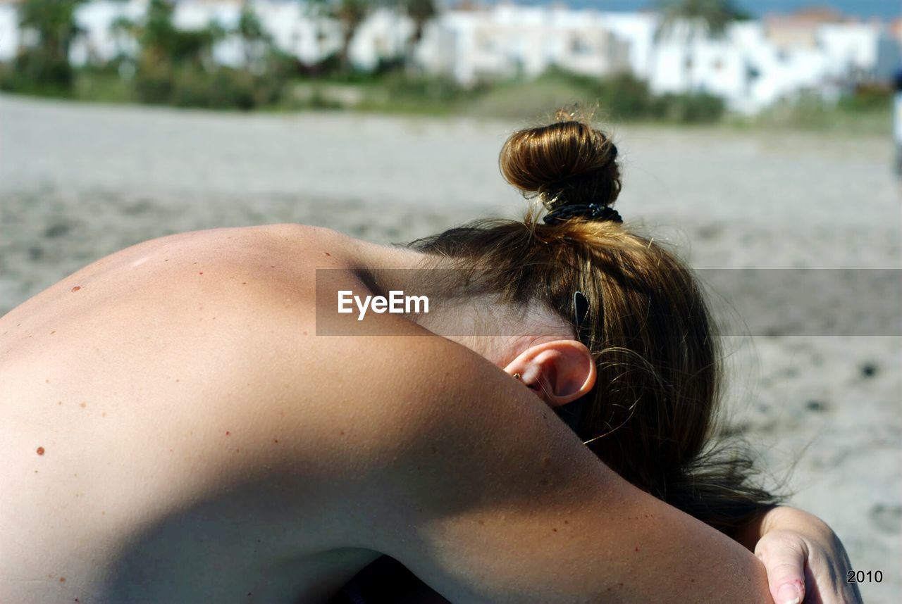 Close-up of naked woman sunbathing at beach