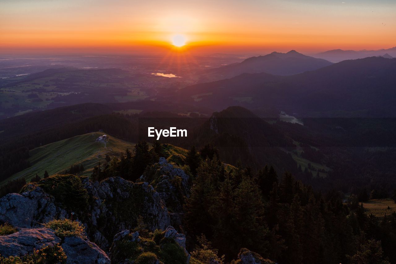 SCENIC VIEW OF MOUNTAINS AGAINST ORANGE SKY