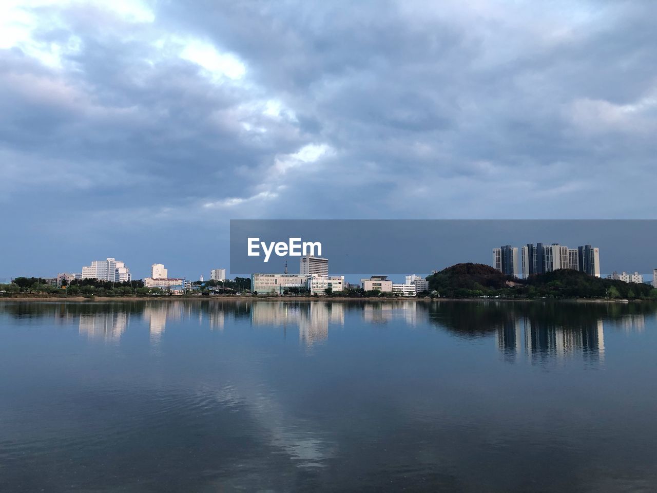 PANORAMIC VIEW OF BUILDINGS BY LAKE AGAINST SKY