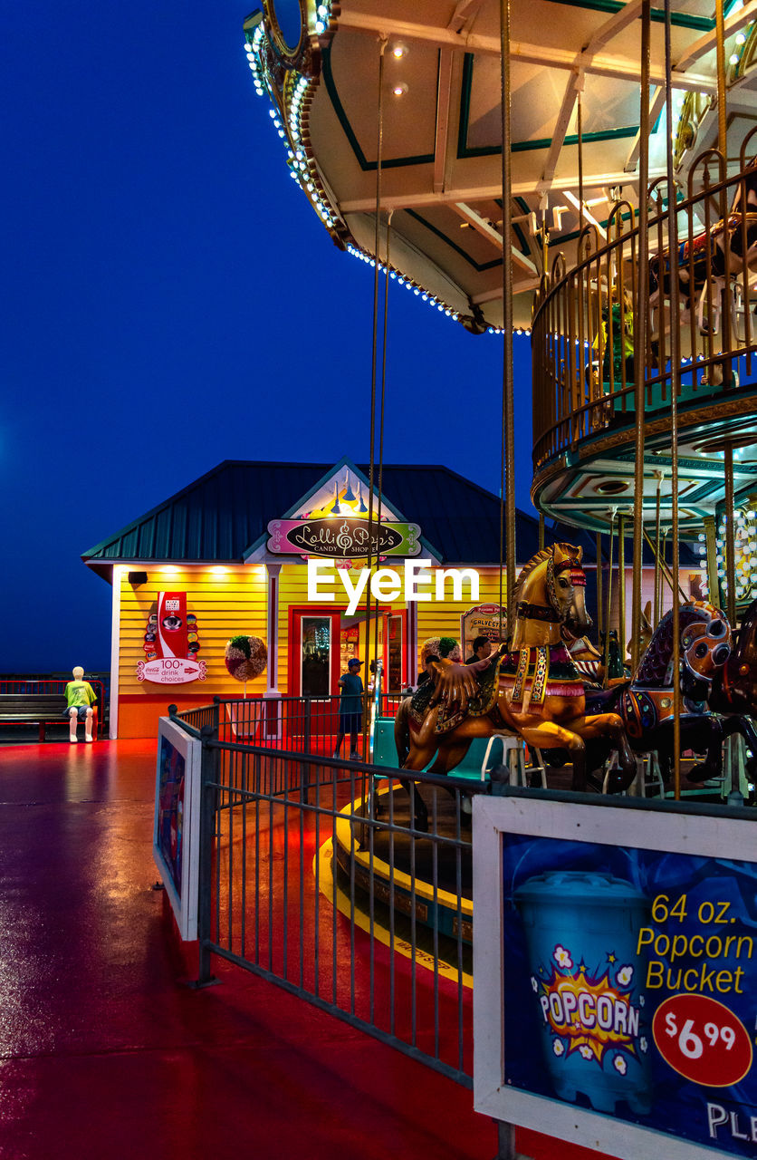 ILLUMINATED FERRIS WHEEL AGAINST BLUE SKY