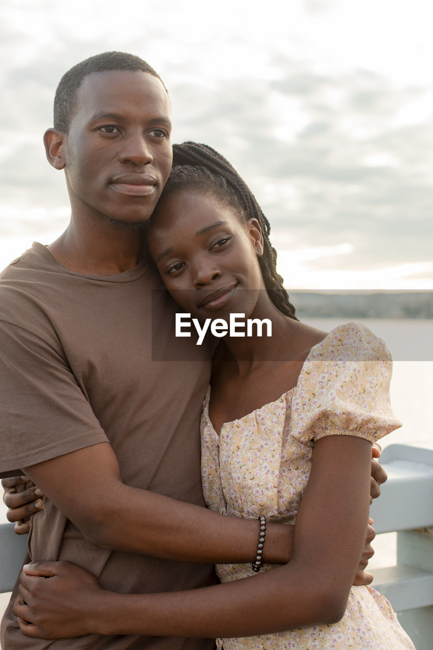 Contemplative couple standing together in front of railing