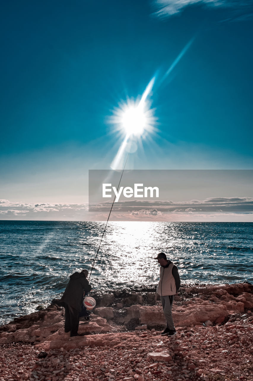 PEOPLE ON BEACH AGAINST SKY