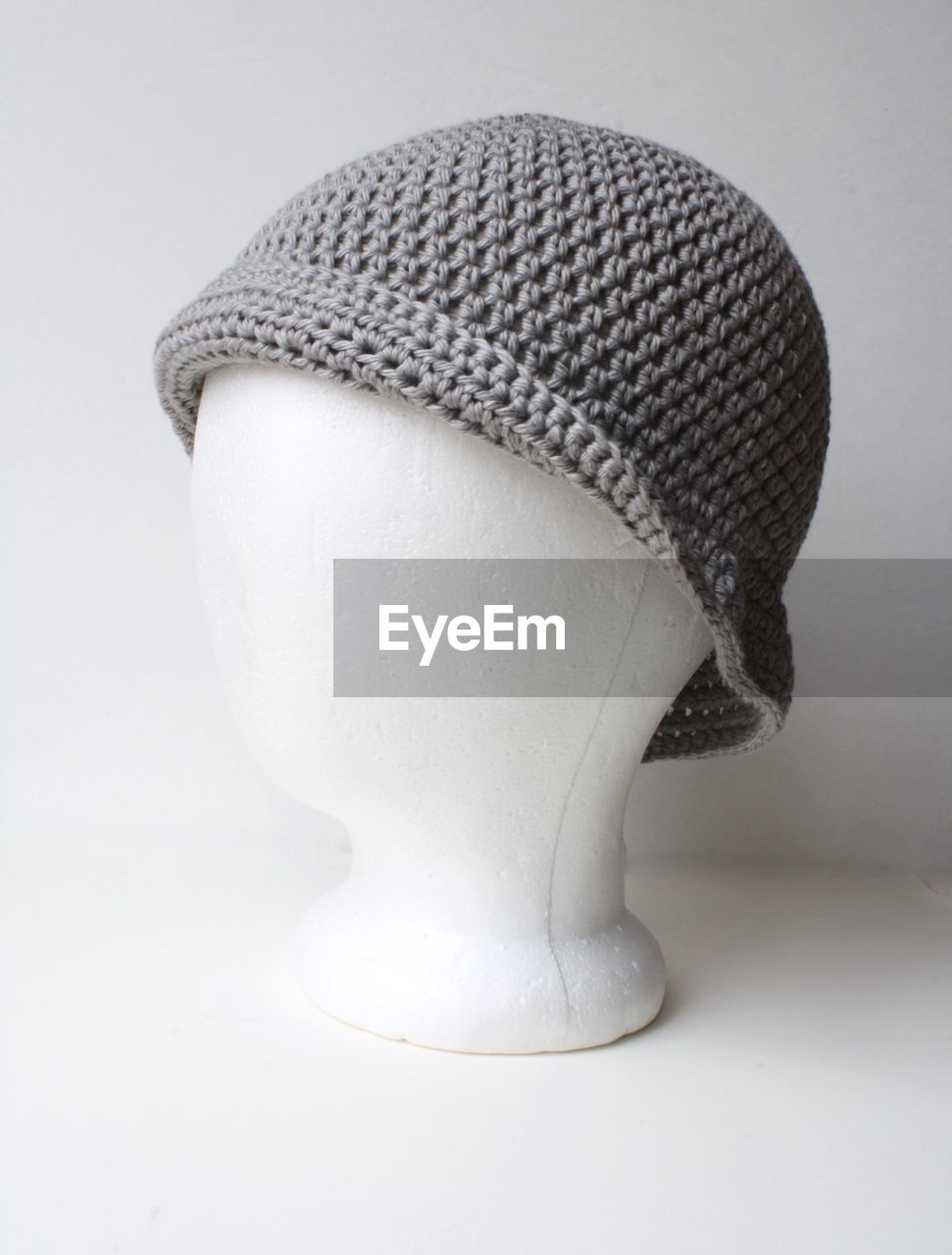 Close-up of knit hat on mannequin over white background