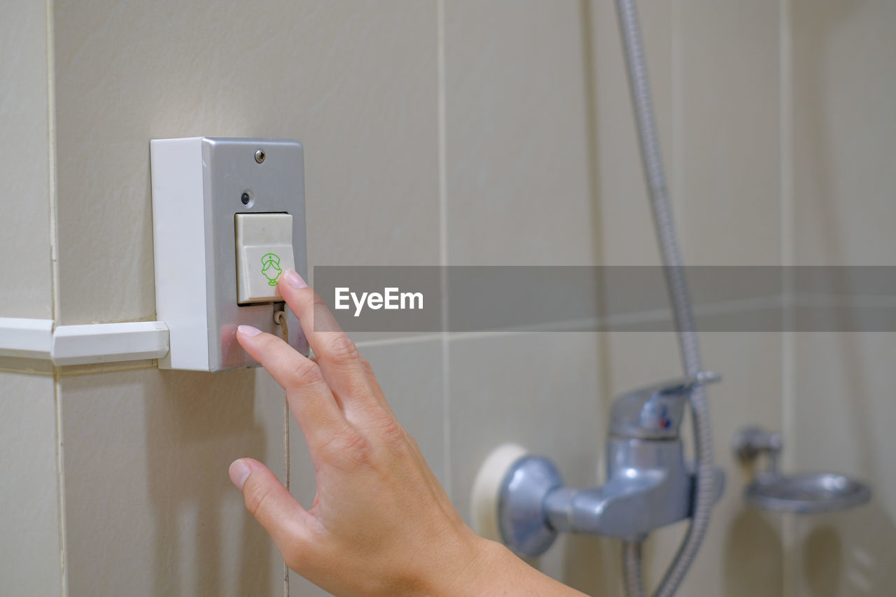 Patient hand pressing the emergency call button in the bathroom. pressing nurse emergency call.