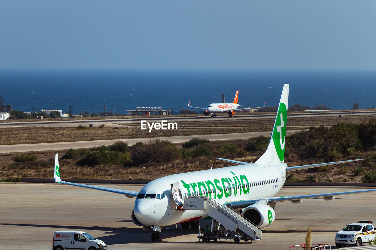 AIRPLANE ON RUNWAY AGAINST CLEAR SKY