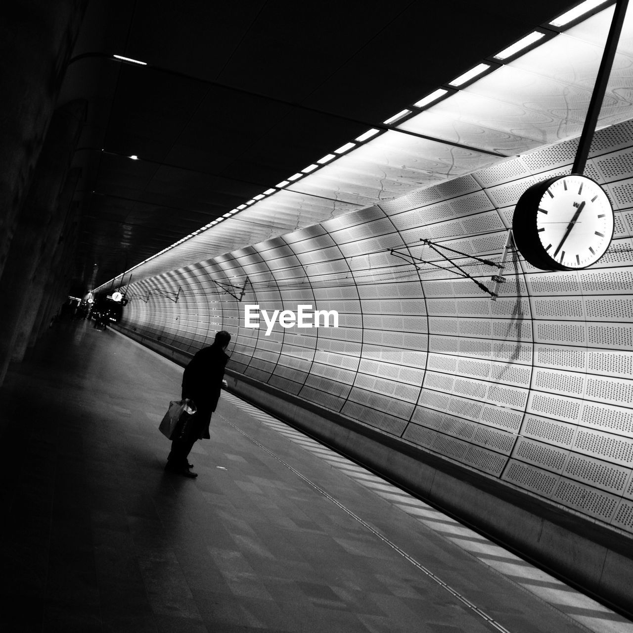 Silhouette man waiting on railway station platform