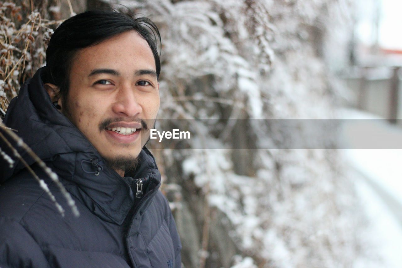 Portrait of smiling man wearing warm clothing during winter