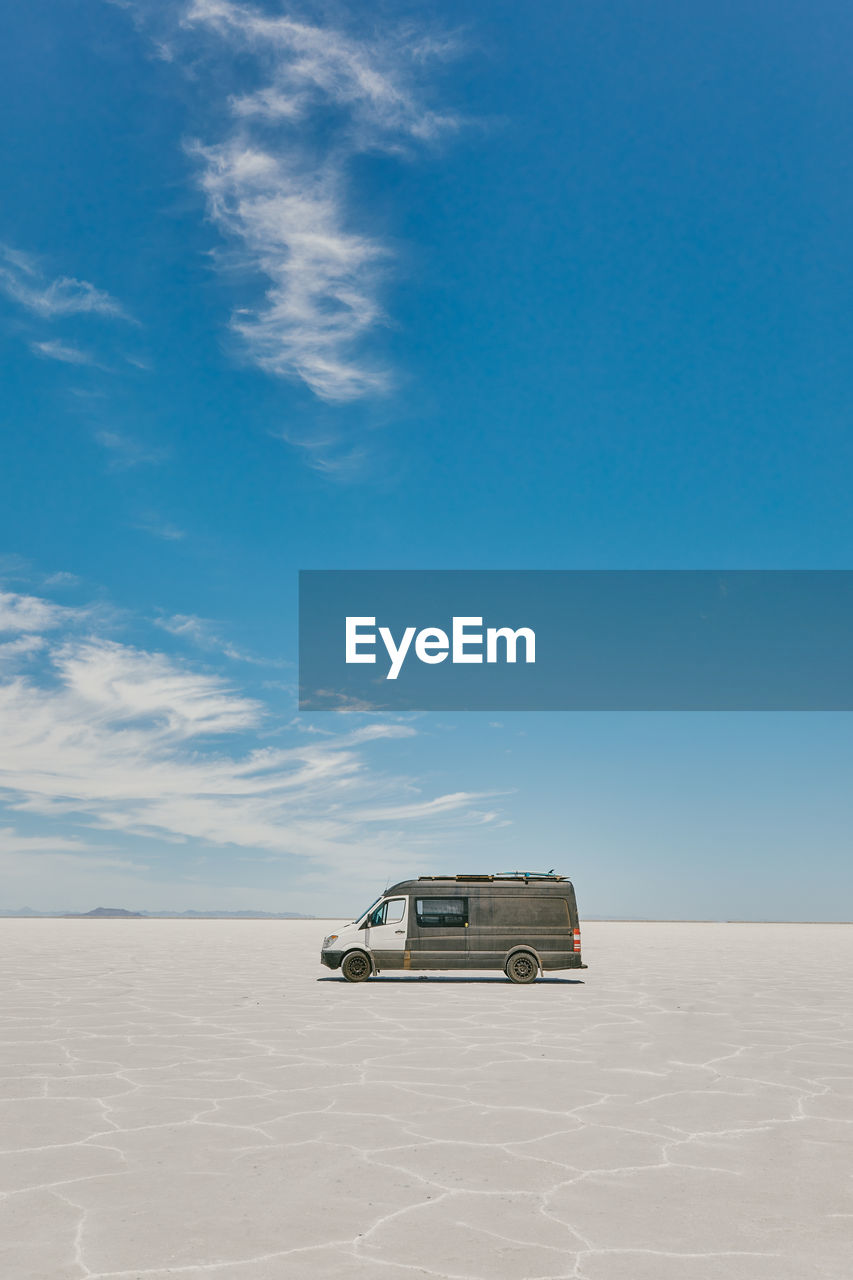 Camper van on bonneville salt flats in utah during a summer road trip.