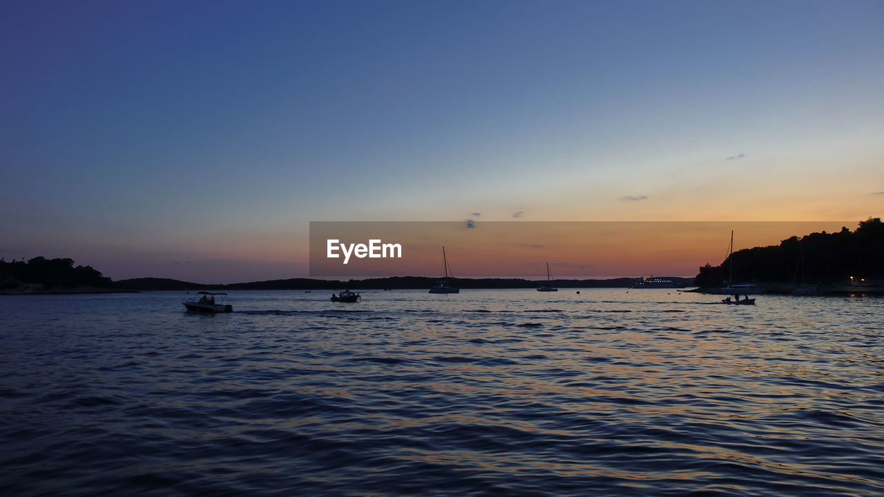 SCENIC VIEW OF SEA AGAINST SKY AT SUNSET