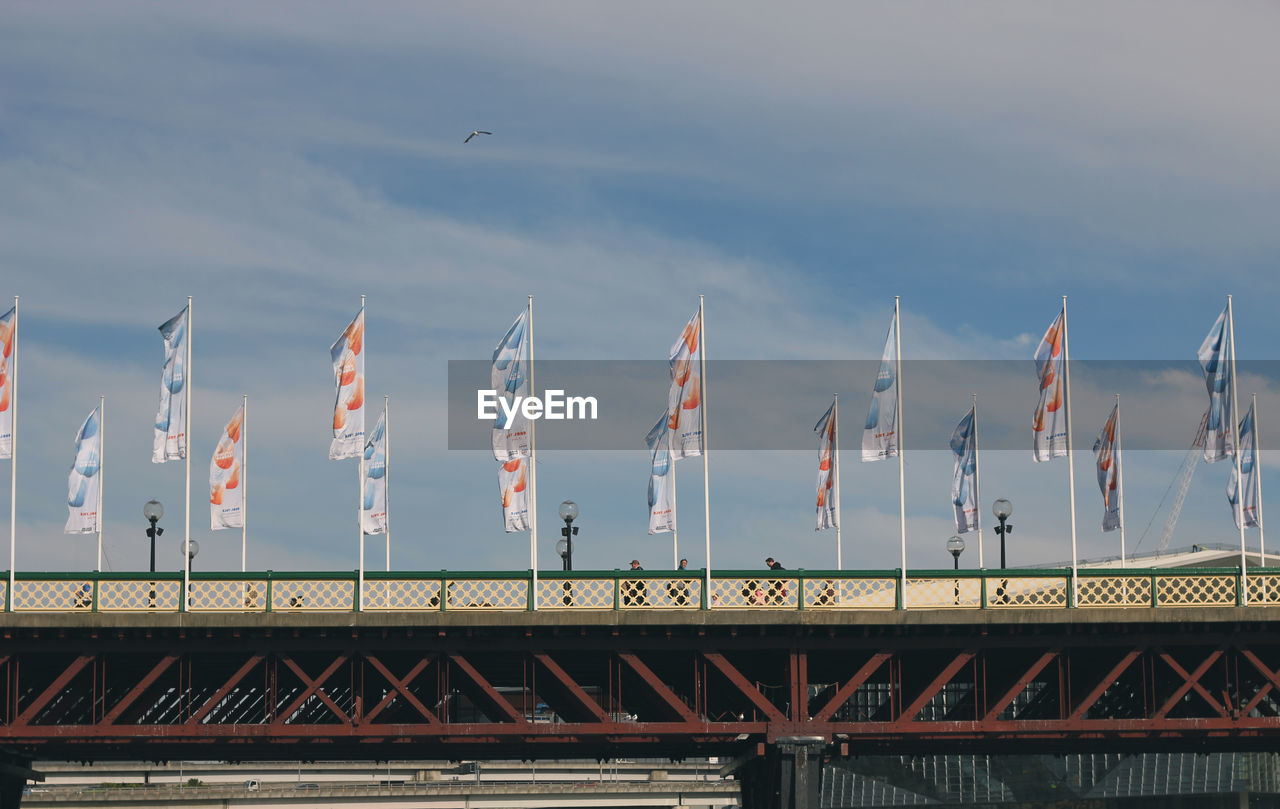 Low angle view of flags against clouds