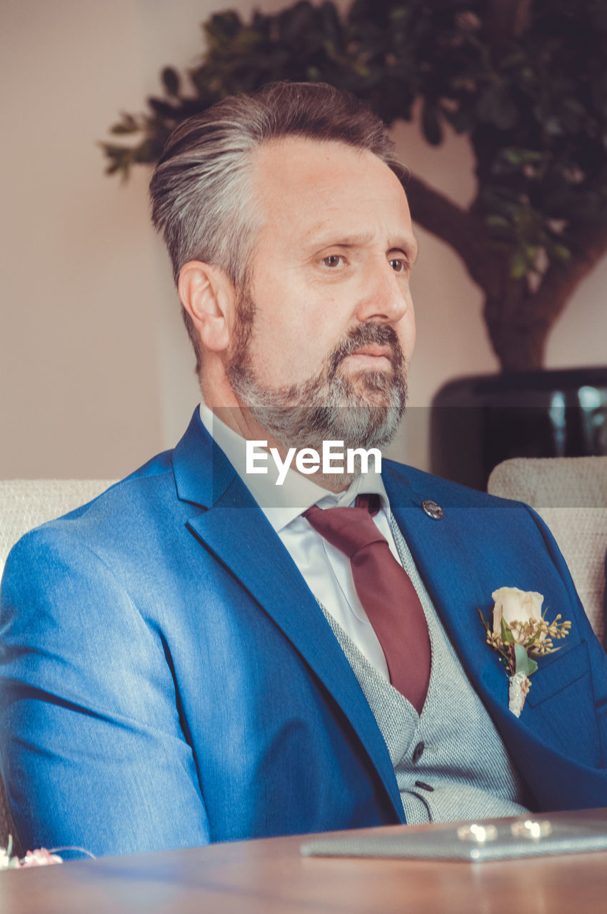 Close-up of mature bridegroom at table