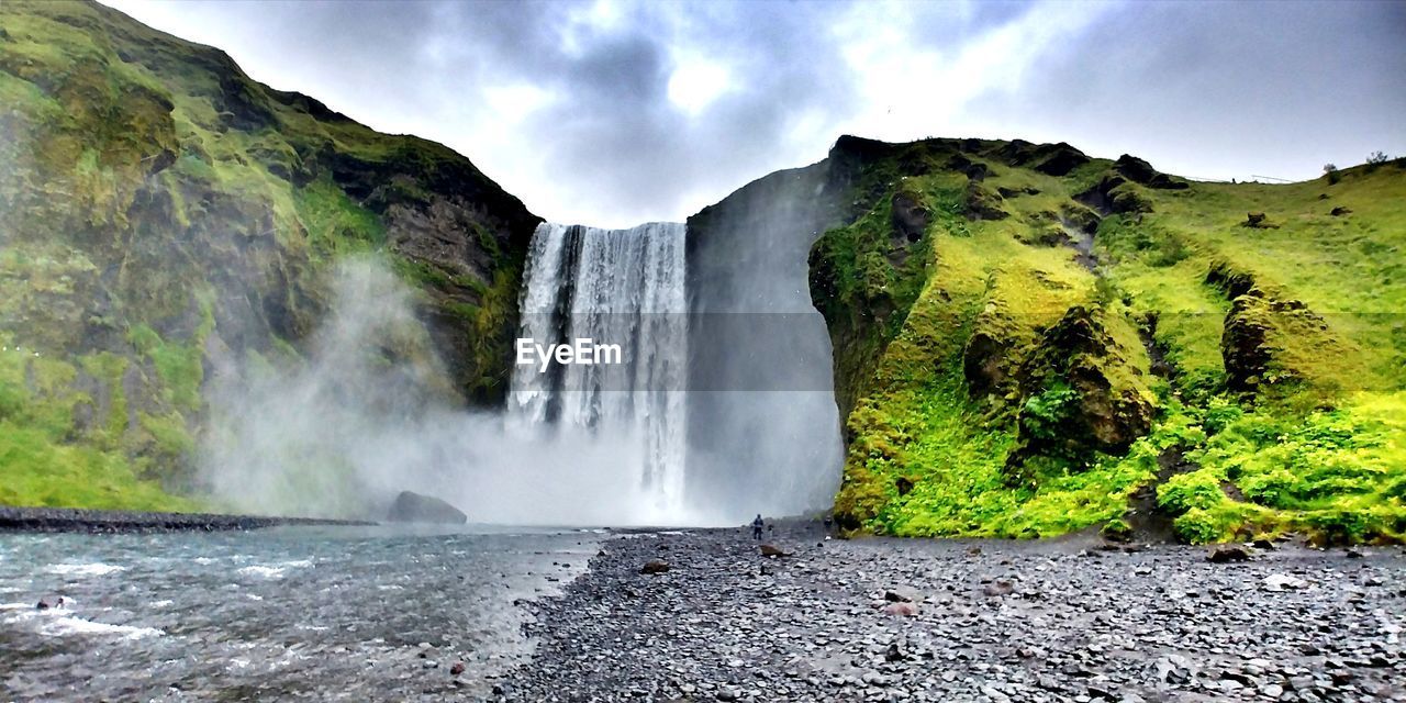 SCENIC VIEW OF WATERFALL AGAINST MOUNTAIN