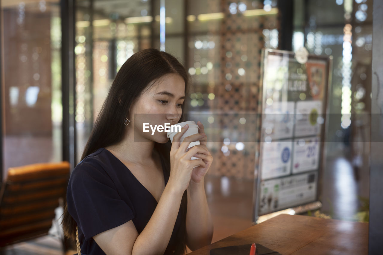 Woman drinking coffee in restaurant