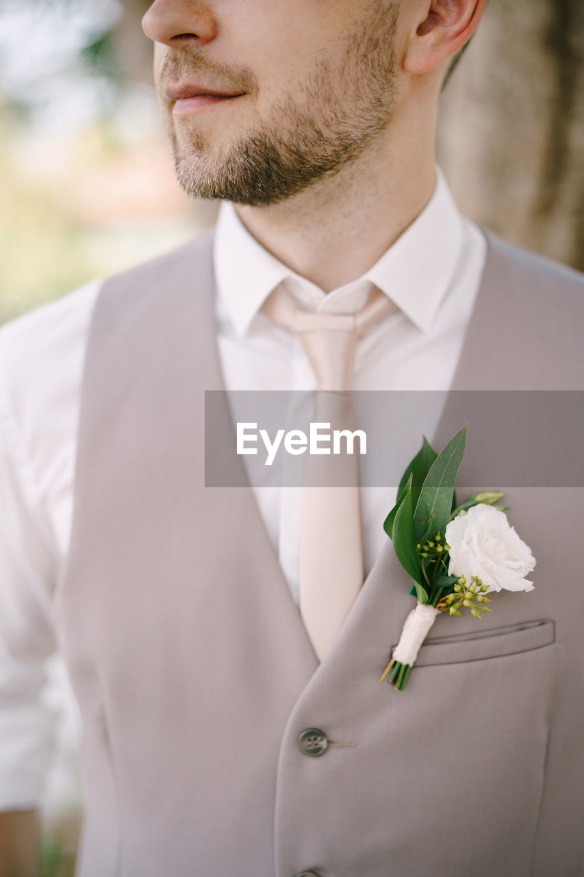 midsection of businessman with bouquet