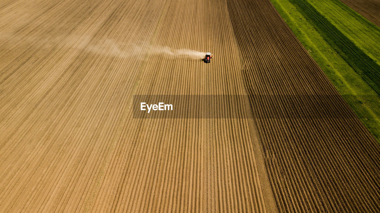 HIGH ANGLE VIEW OF PERSON ON ROAD AMIDST FIELD