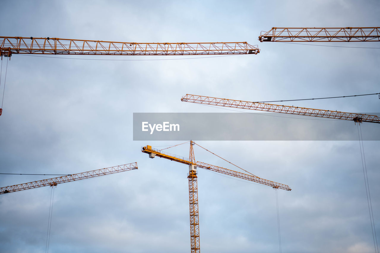 LOW ANGLE VIEW OF CRANE AT CONSTRUCTION SITE AGAINST SKY