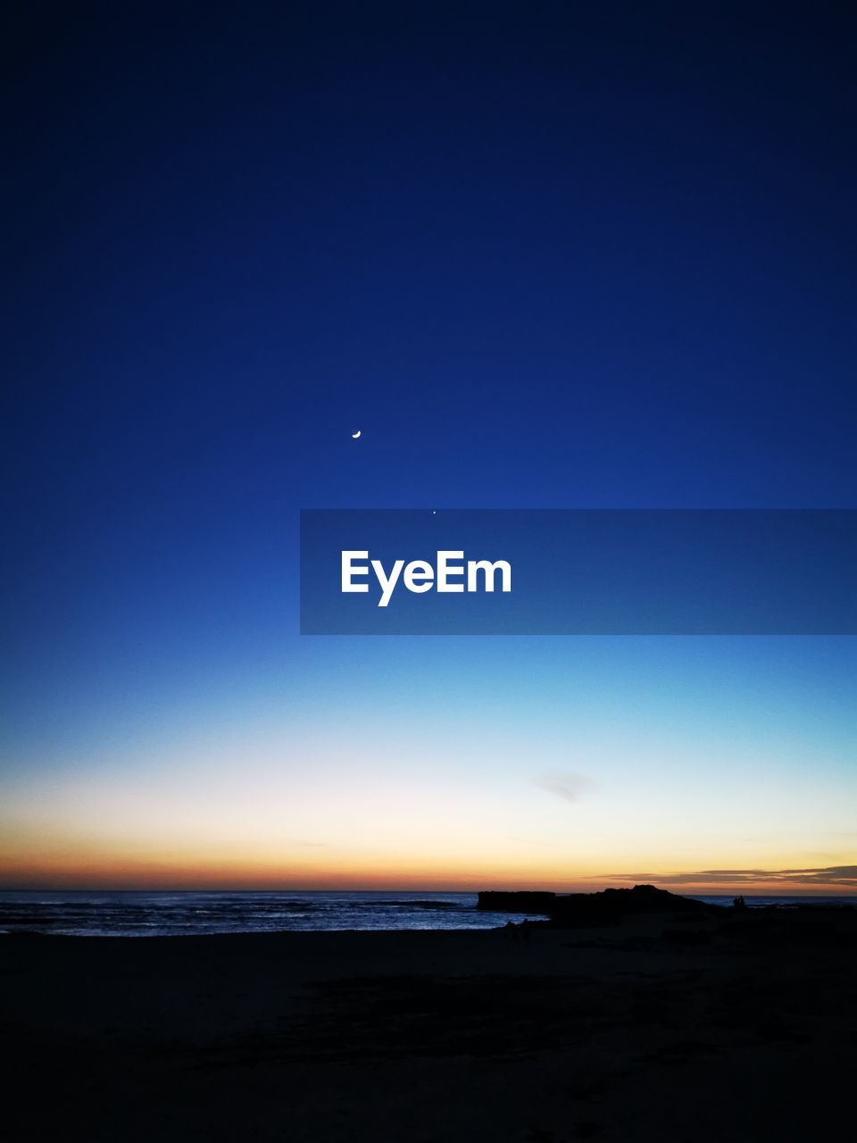 SCENIC VIEW OF SEA AGAINST BLUE SKY AT NIGHT