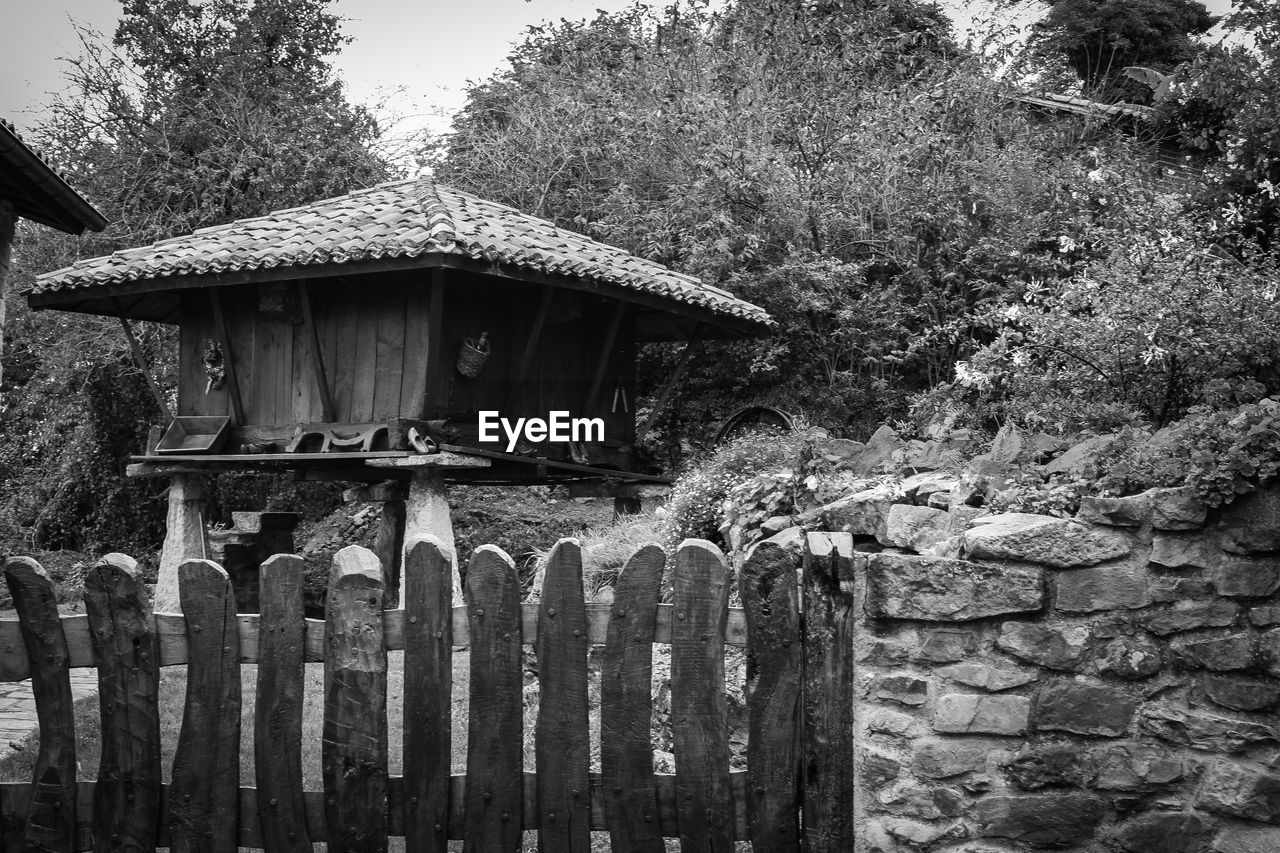 Hut on field against trees