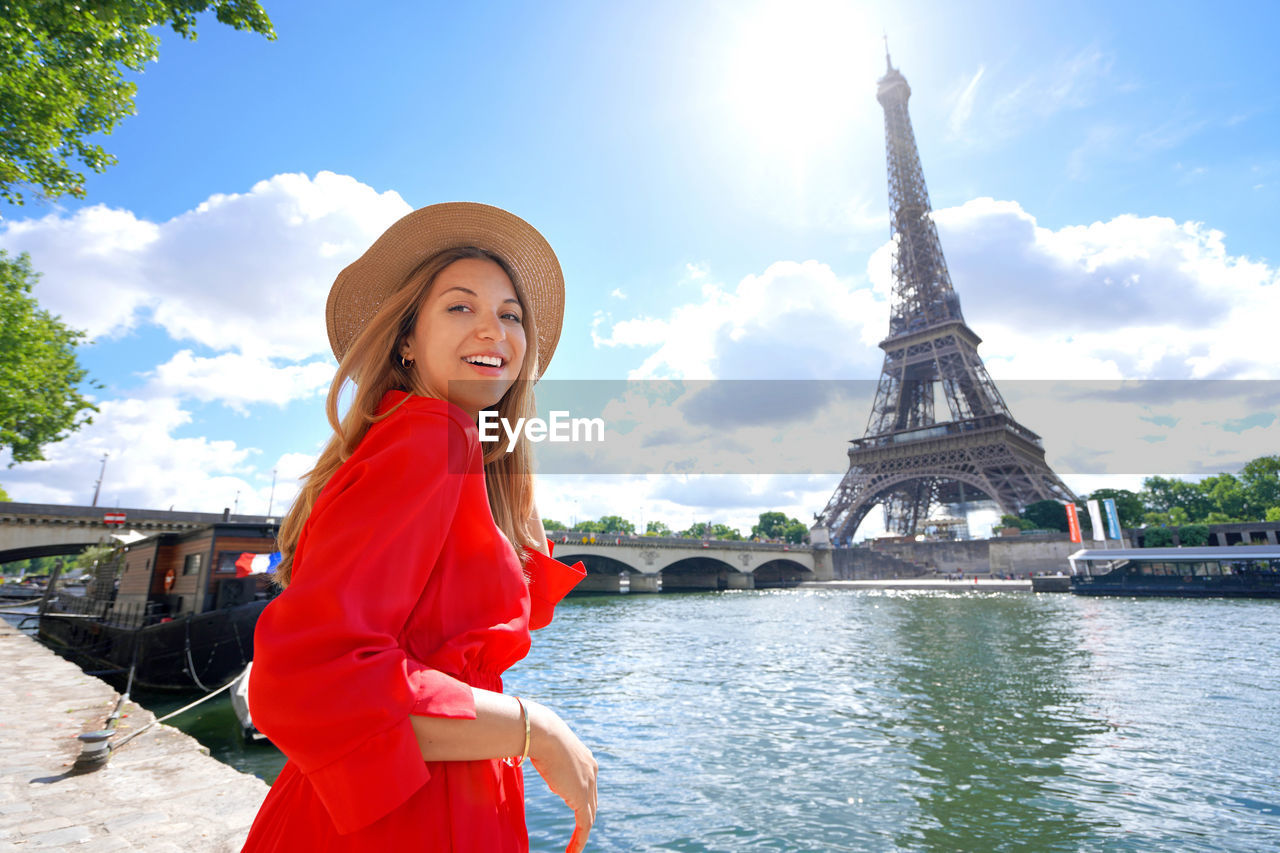 Woman walking along the bank of the seine river with the eiffel tower in paris, france