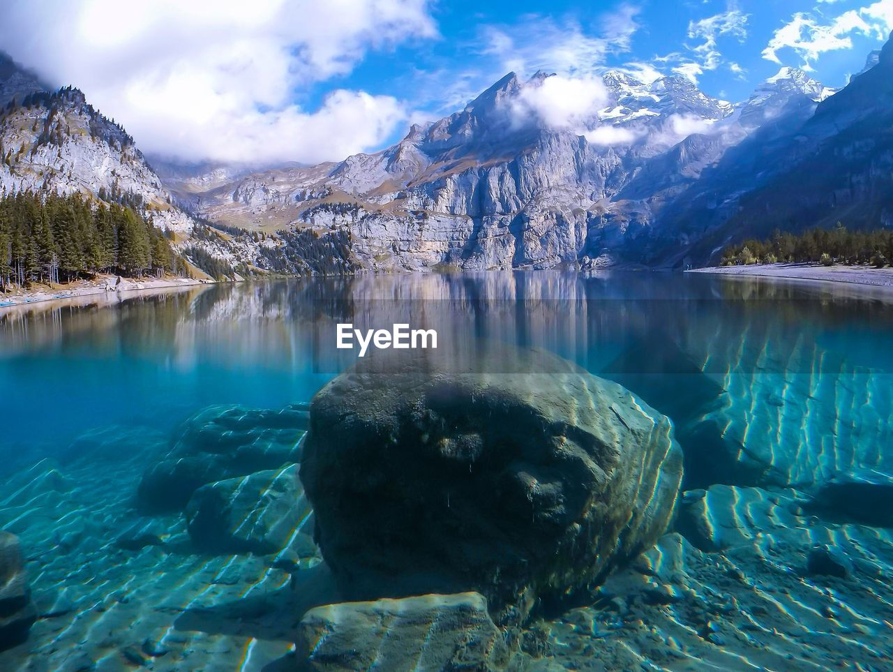 Rocks in oeschinen lake against sky