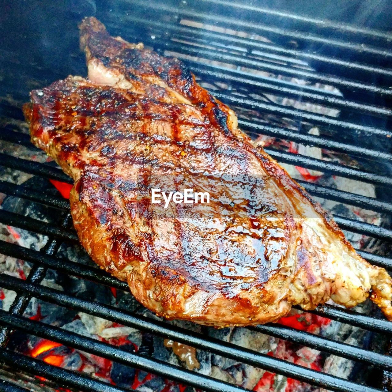 CLOSE-UP OF MEAT ON BARBECUE GRILL AGAINST SKY