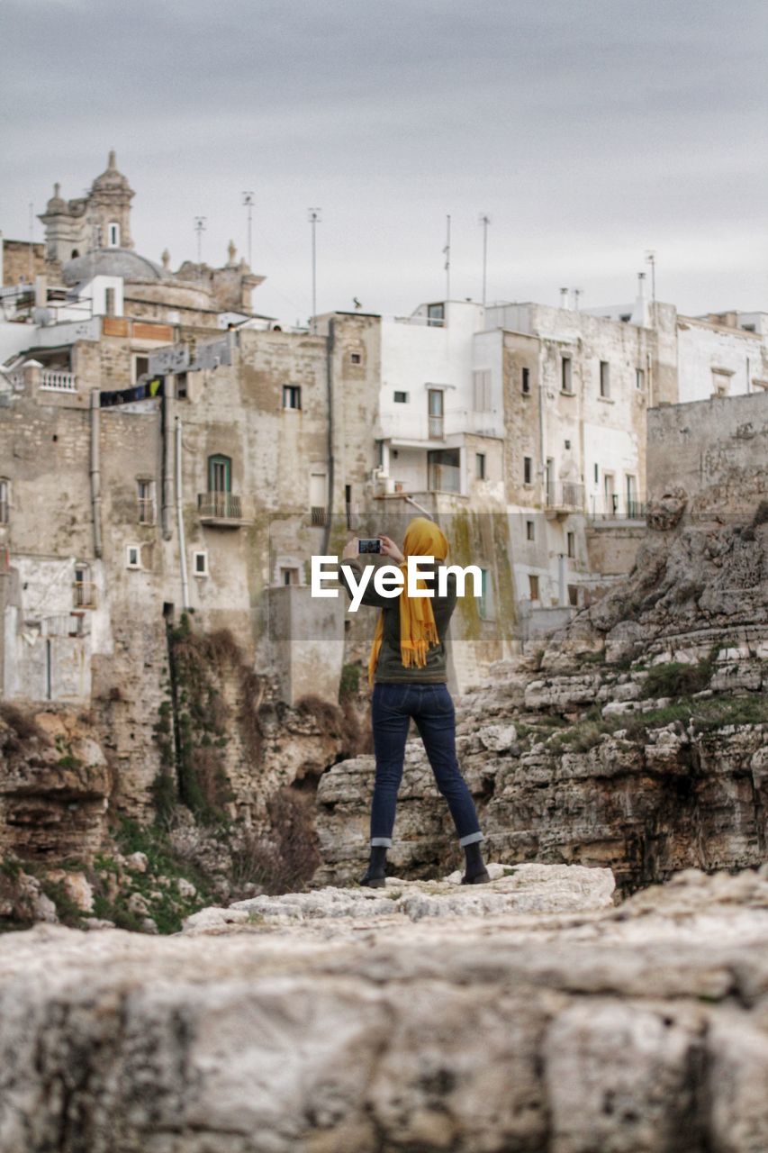 Rear view of woman photographing at historic site