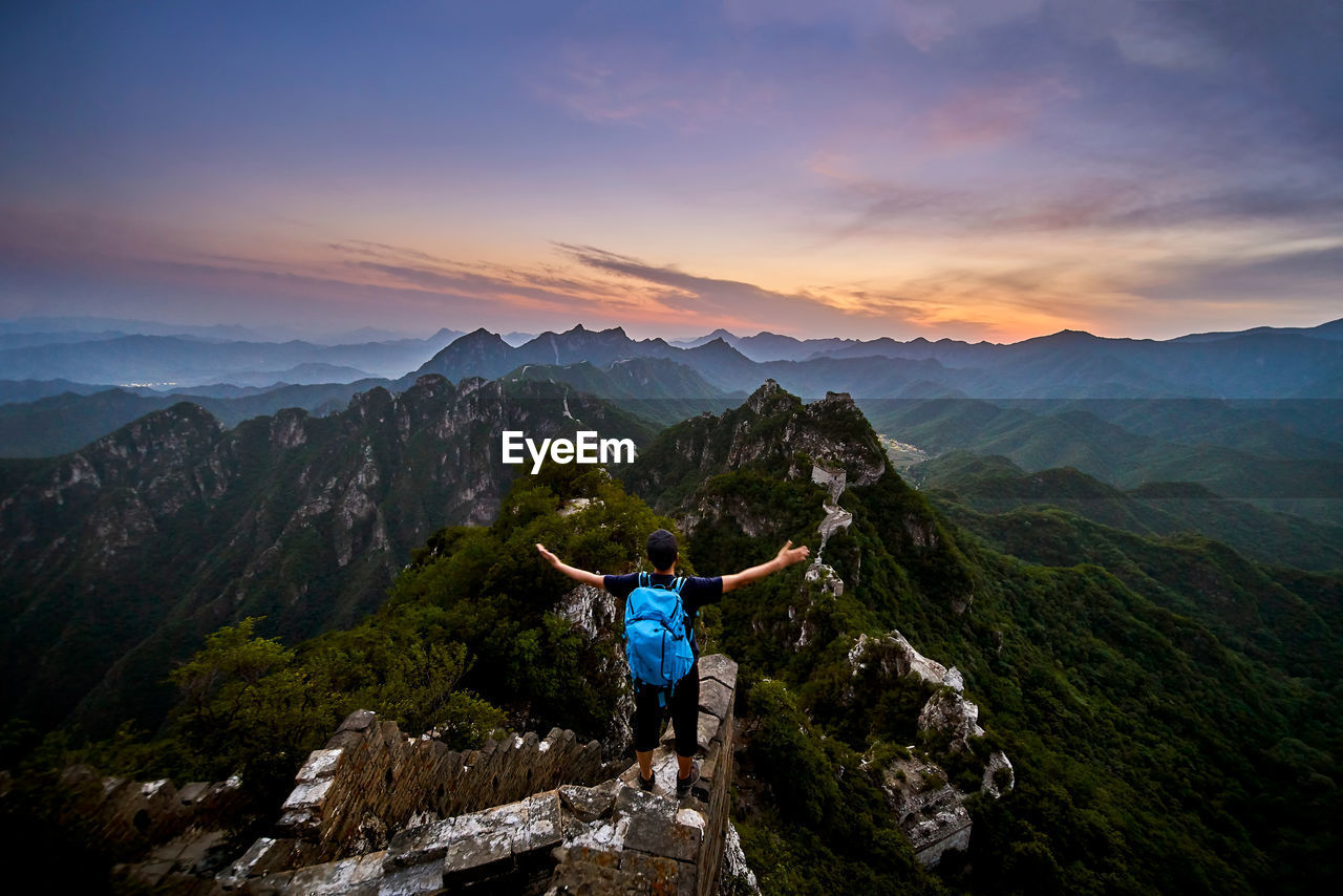 Man standing on mountain during sunset