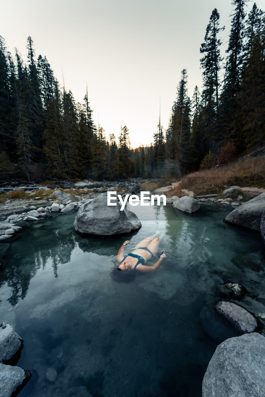 Woman floats in small pool hot spring at jerry johnson hot springs in idaho usa