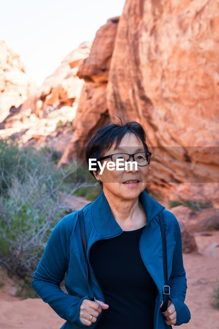 Portrait of senior asian woman hiking in the desert landscape