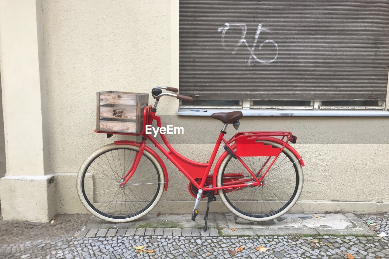 Bicycle parked against brick wall