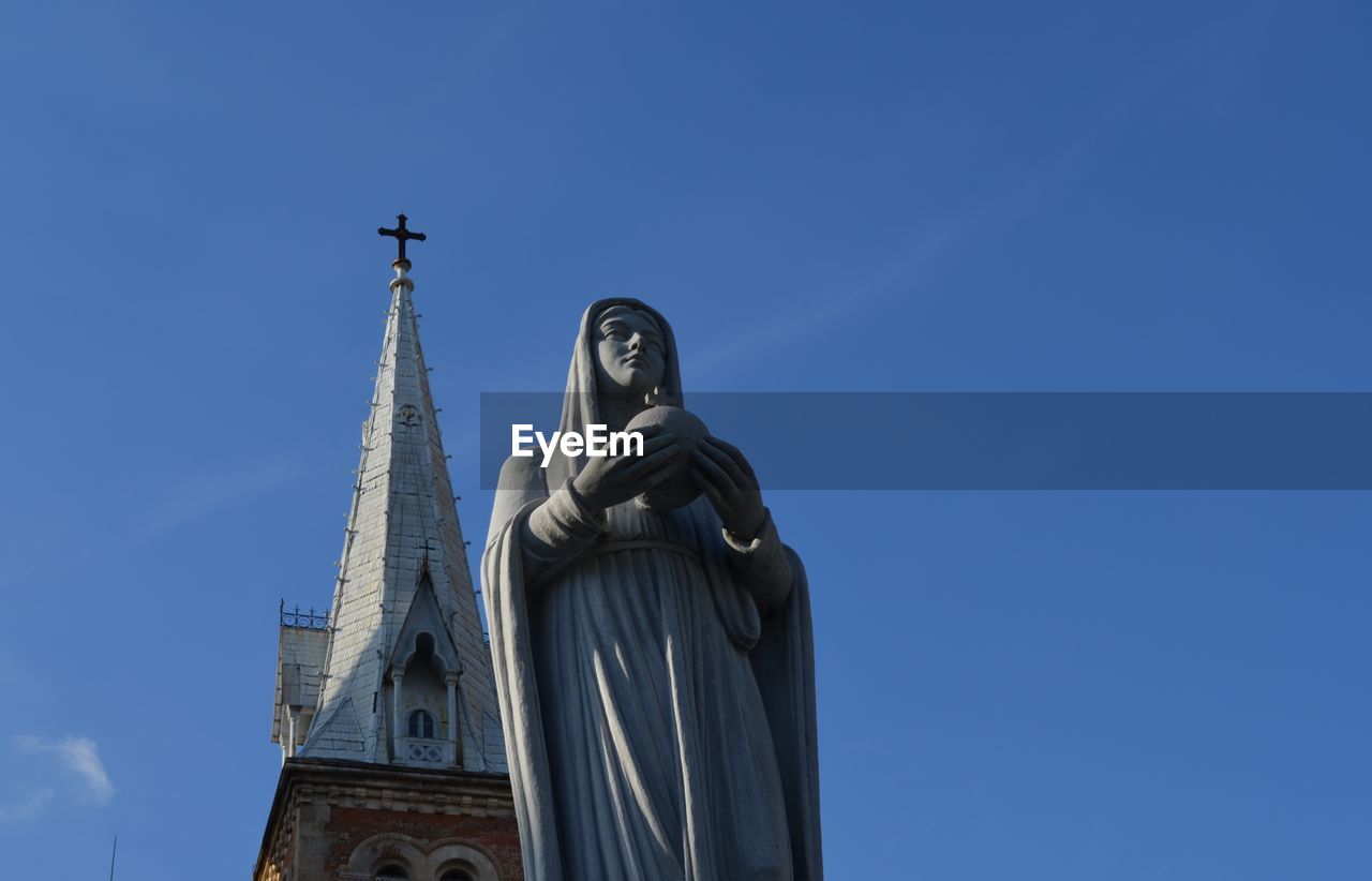 Low angle view of mother mary statue against church