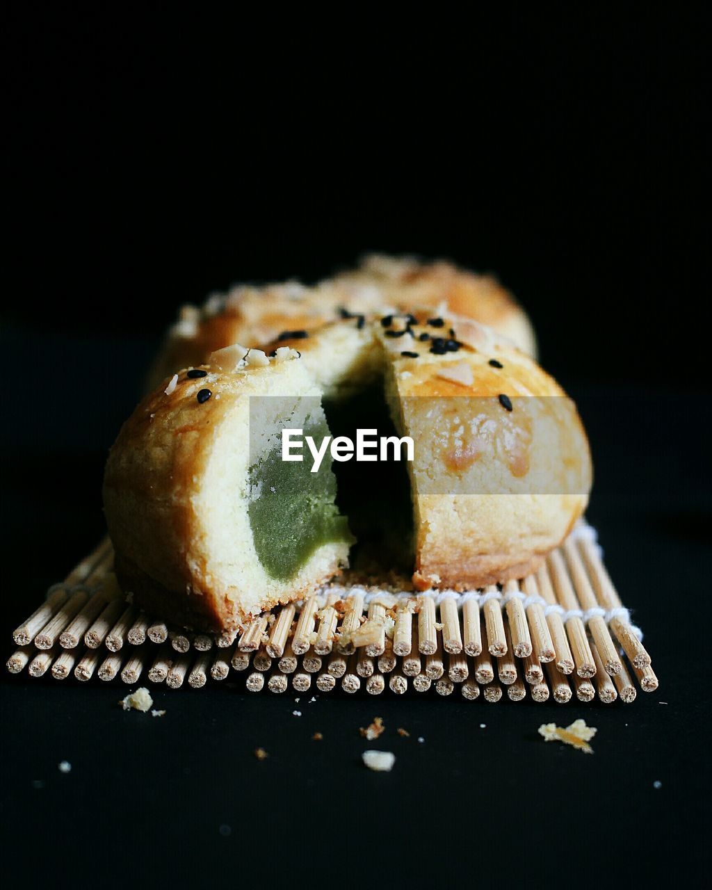 Close-up of moon cake on place mat against black background