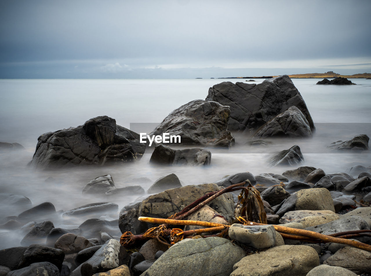 Rocks on sea shore against sky